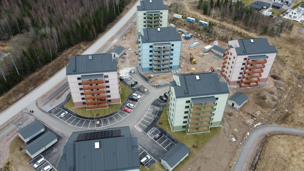 Aerial photograph of residential buildings under construction in Sweden, surrounded by forest.